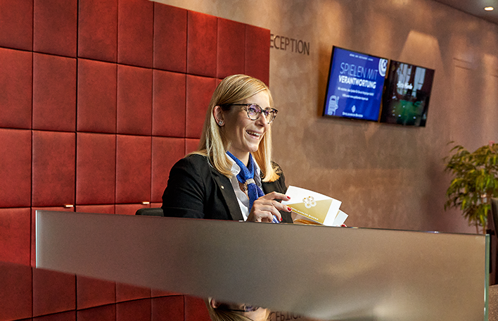 Eine Mitarbeiterin am Empfangsbereich eines Casinos