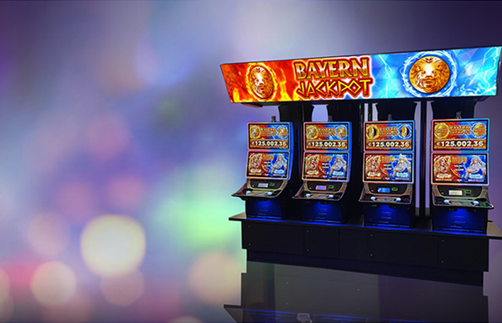 Vier Spielautomaten nebeneinander mit einem Bayern Jackpot-Bildschirm darüber